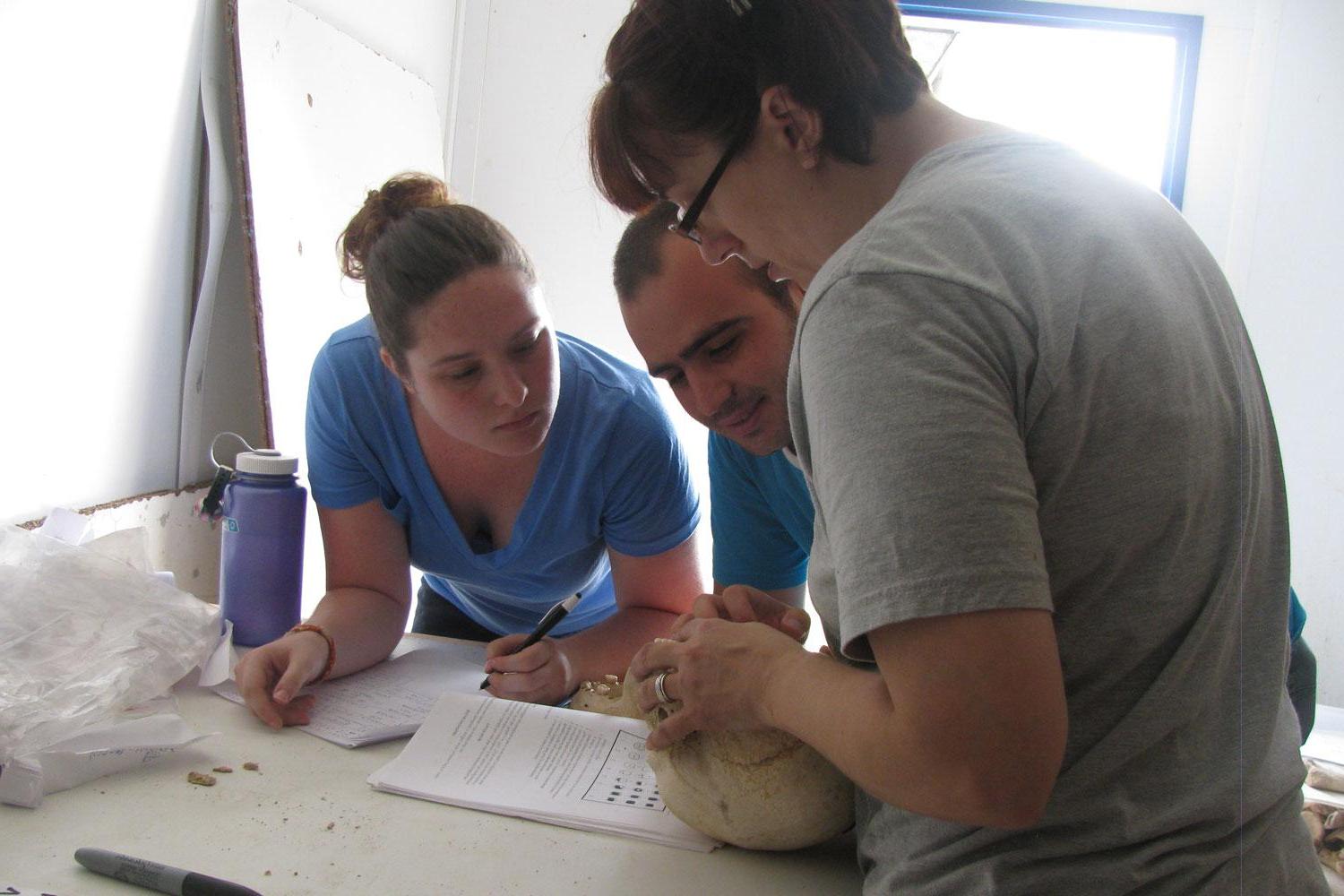 博天堂官方的学生詹妮弗·赖特和凯特琳·麦凯彻恩与阿尔巴尼亚学生马龙一起分析阿尔巴尼亚的骨骼.