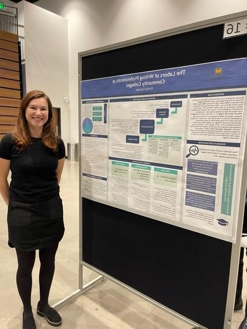 Emily Forcier stands next to a poster detailing her research work